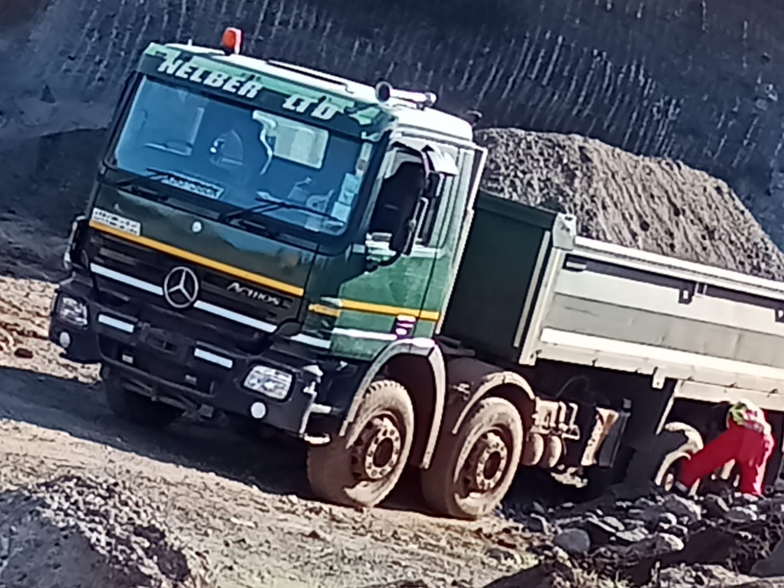 Nelberfarm Actros truck loading gravel with a grabber crane