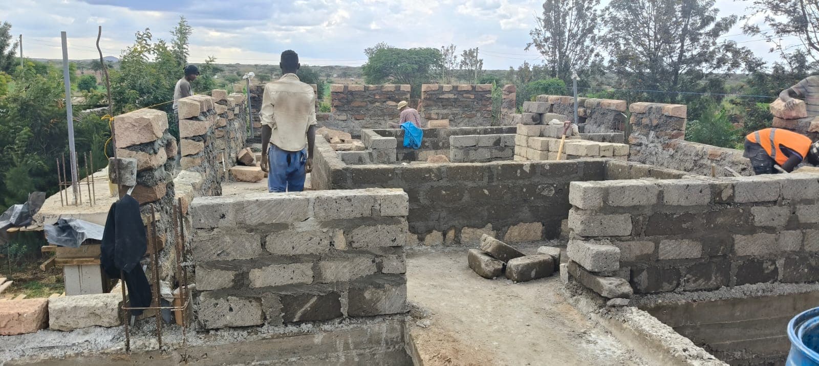 Block wall building site with a worker on the wall top