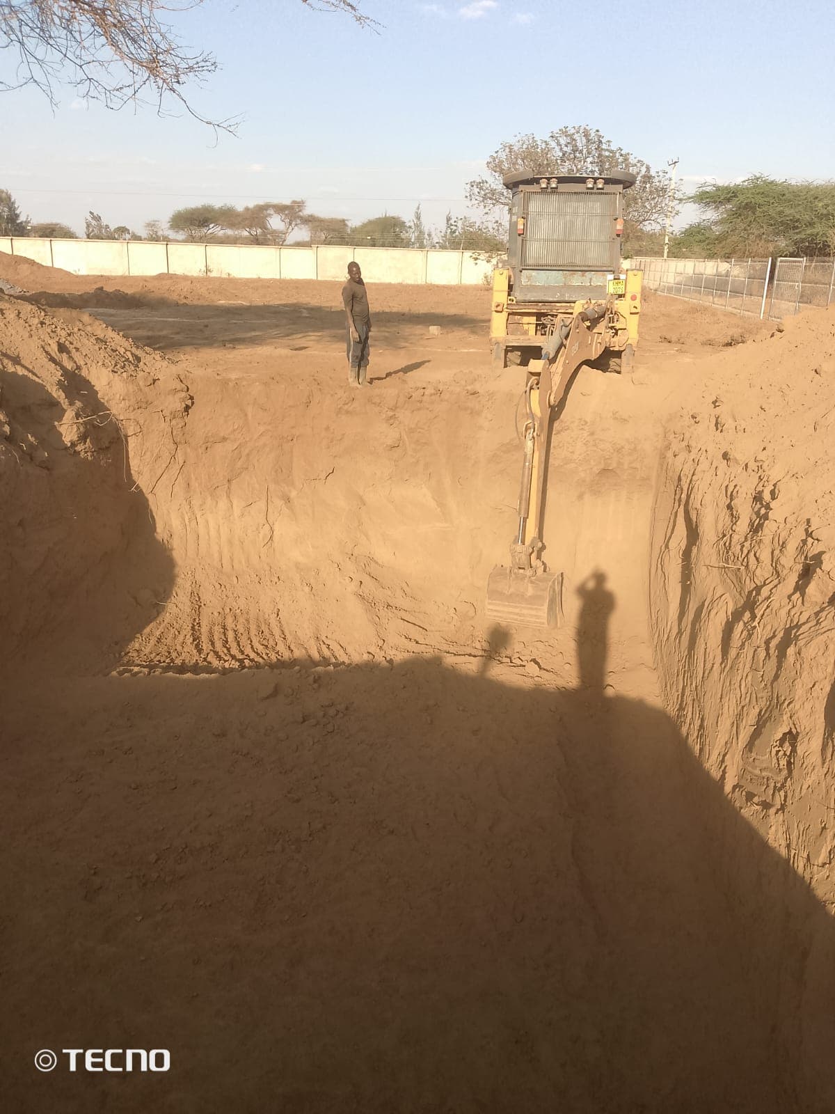 Excavator digging a deep foundation trench